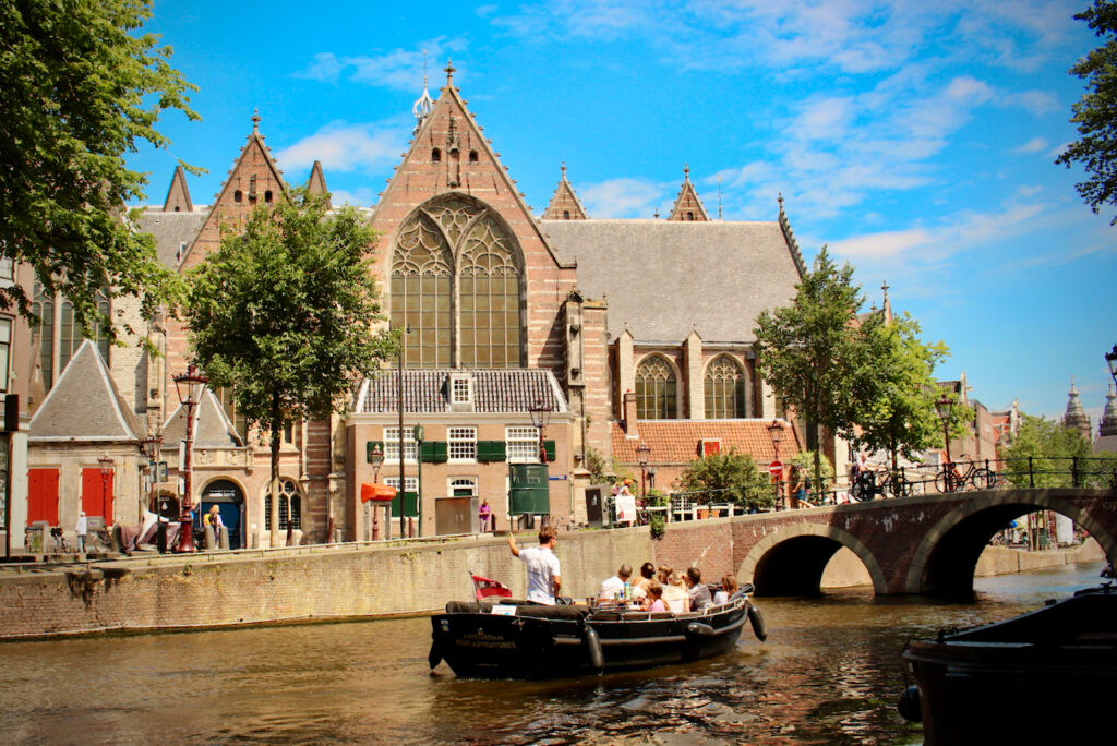 Amsterdam Boat Adventures giving a tour on a canal in Amsterdam in front of the Old Church