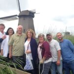 A tour group in front of a windmill on our Private Amsterdam Windmill Tour