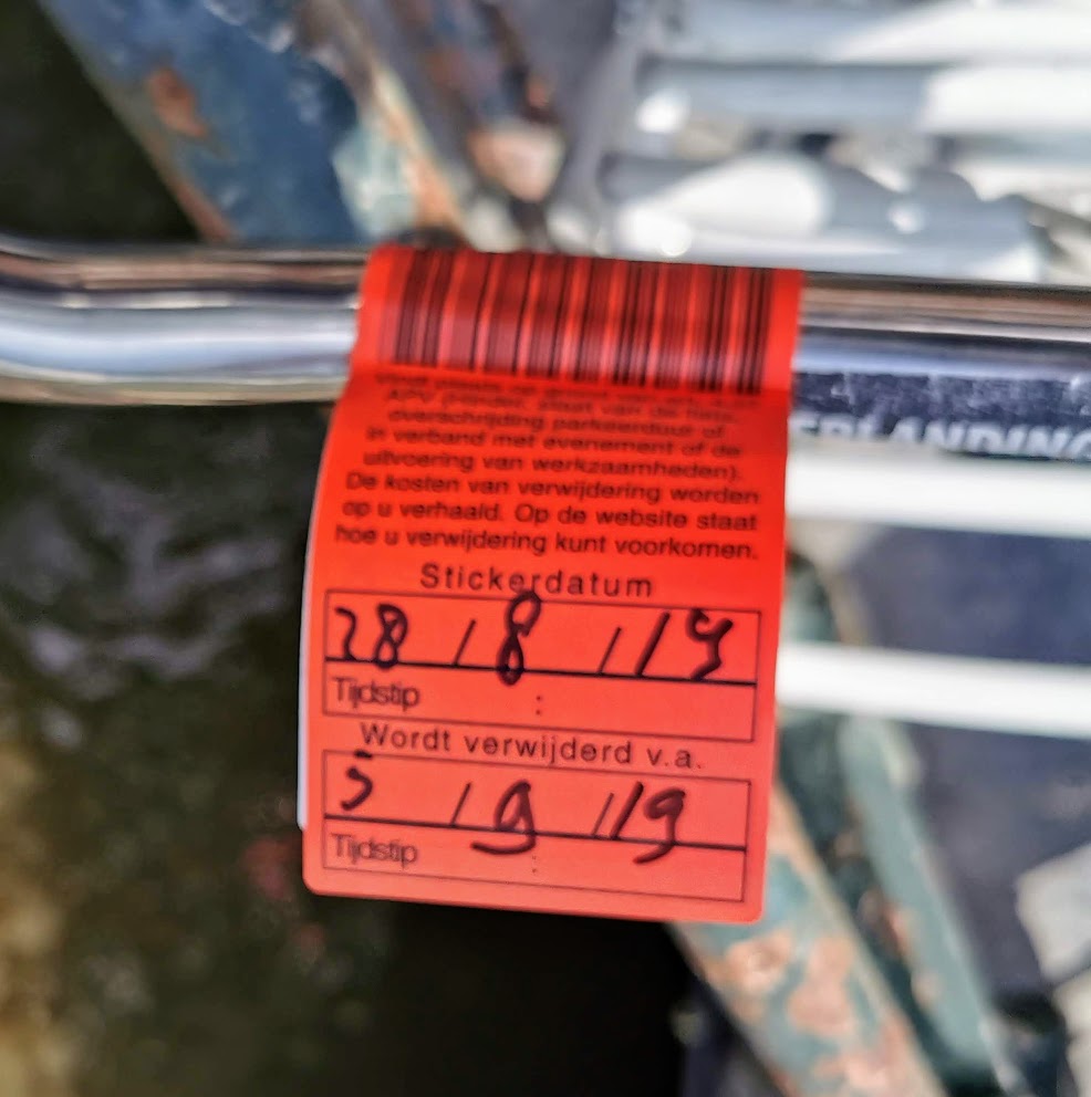 The notice sticker on and abandoned Amsterdam bike that wit will be removed by a certain date