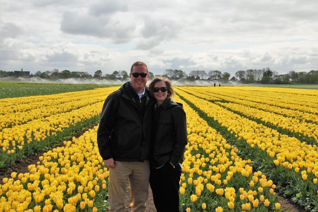 Two people standing in a field of yellow tulips on a Private Keukenhof Tulip Tour