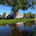 Farmhouyse reflected in a small waterway on a Countruyside Tour